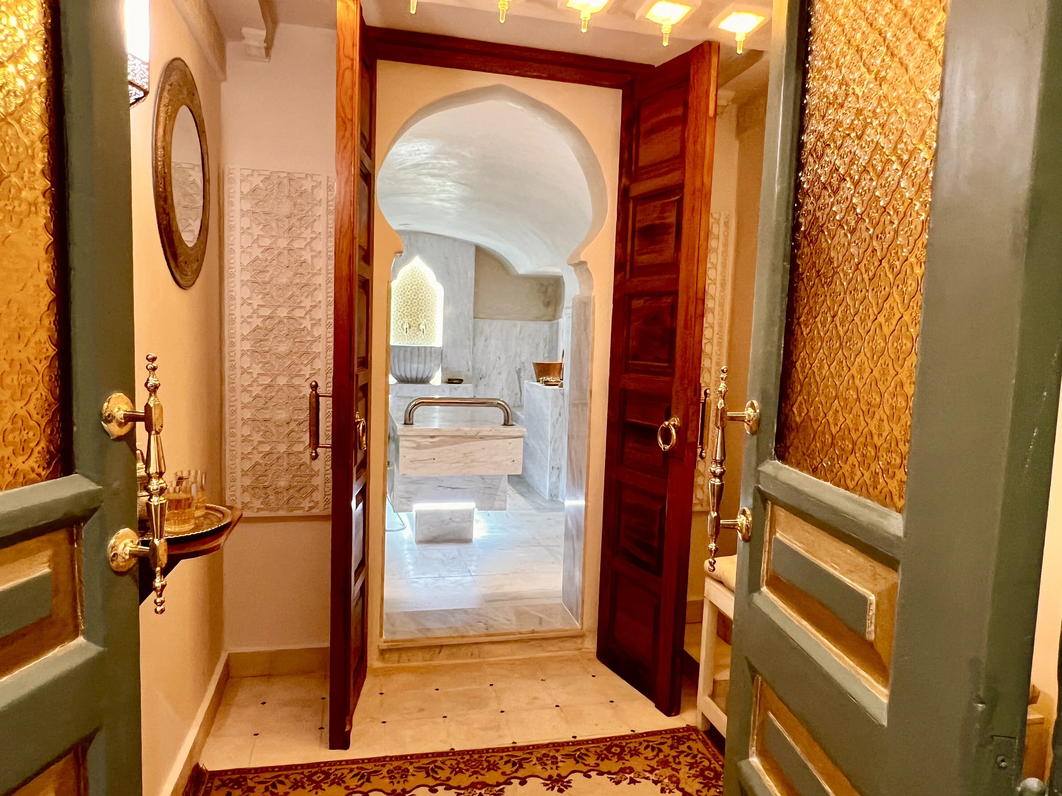 Carved cedar doors and Moorish arch at the entrance of Spa du Calife - Riad Le Calife Fes